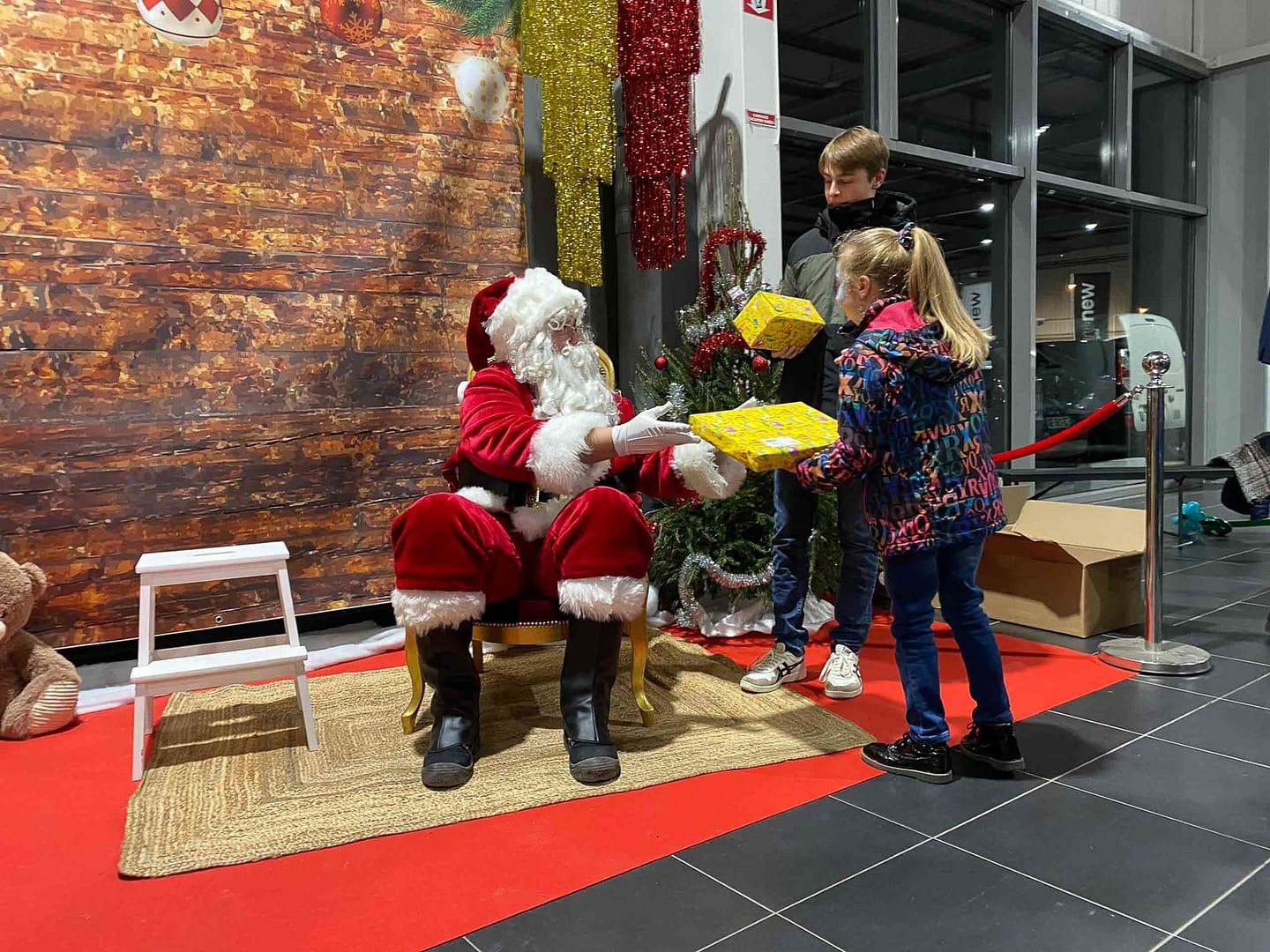 Le Père Noël et son lutin remettent les cadeaux aux enfants lors de l'arbre de Noël Gueudet organisé par 9P Production